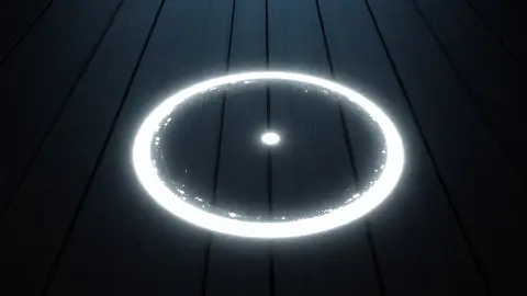 Glowing circle with a dot in the middle drawn on dark wooden planks