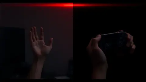 Bare hands and hands holding VR controllers side by side in a dim room
