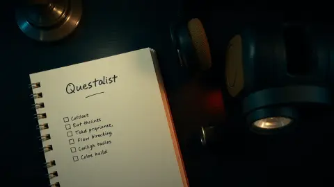 Handwritten checklist beside a VR headset and flashlight on a dark table