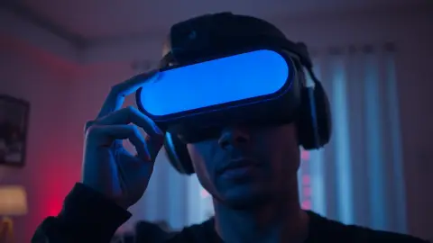 Person adjusting a VR headset over round glasses with red beams behind