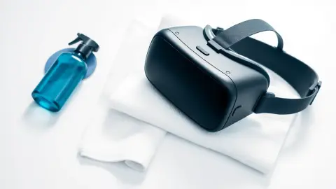 VR headset on a towel beside a microfibre cloth and a fresh facial cover