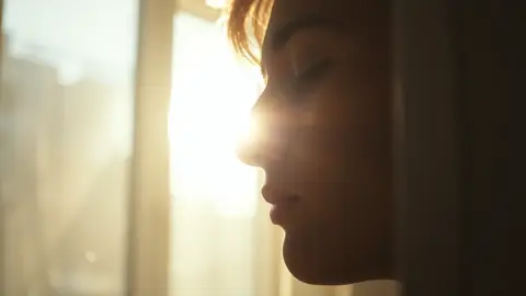 Calm person breathing quietly near a sunlit window