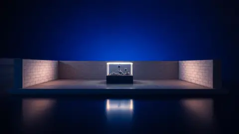 Glowing light trail bouncing off two walls of a miniature block arena on a table